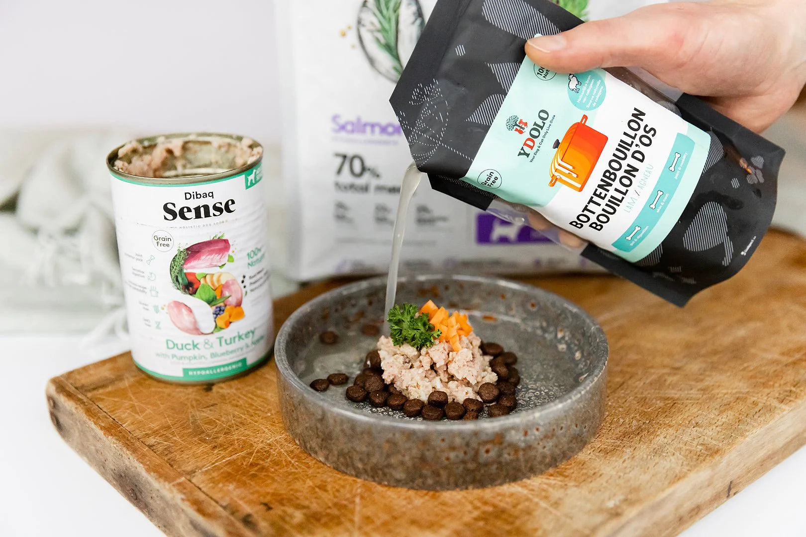 Hondenvoer in kom met brokken en vers vlees, aangevuld met idool bottenbouillon als topper